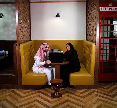 Two professionals engage in a focused discussion within a private booth at a Servcorp coworking space in Saudi Arabia.