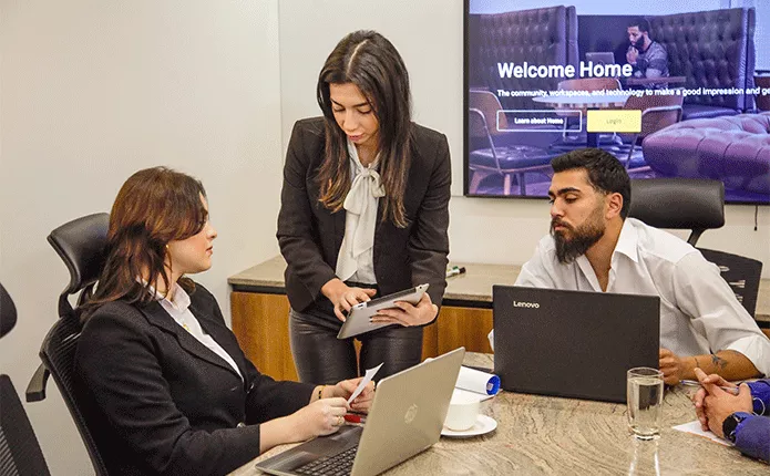 Boardroom at Qubic Square with people meeting and presenting using high-tech, fully equipped facilities.