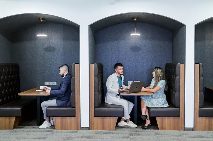 Coworking Space at Qubic Square with clients working and collaborating in an open hot desk area.