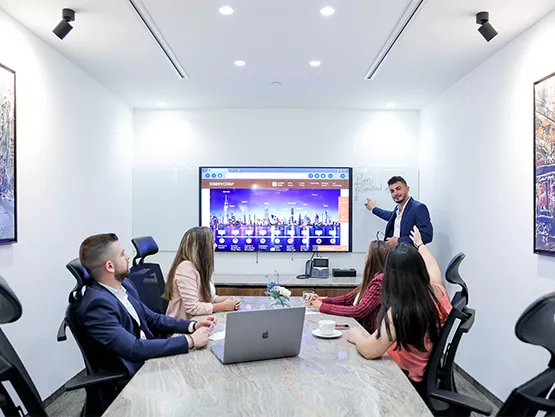 Boardroom at Qubic Square with people meeting and presenting using high-tech, fully equipped facilities.